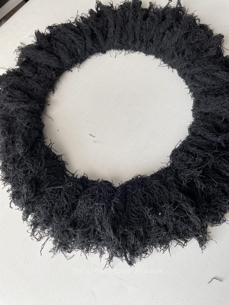 One row of creepy cloth pieces attached to a round wreath form. 