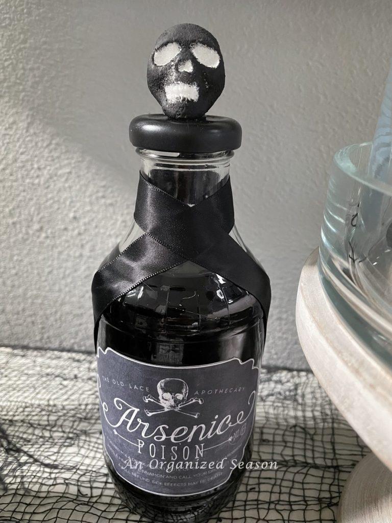 A bottle of arsenic with a black skull on top.