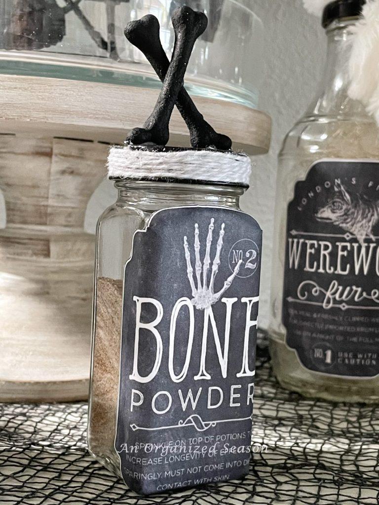 A jar of bone powder with crossed bones on top of cap. 