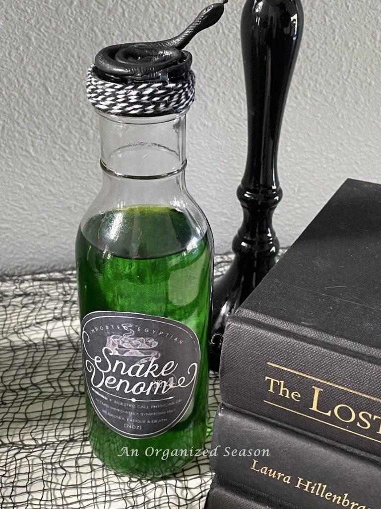 A bottle of green snake venome with a coiled snake on the cap. 