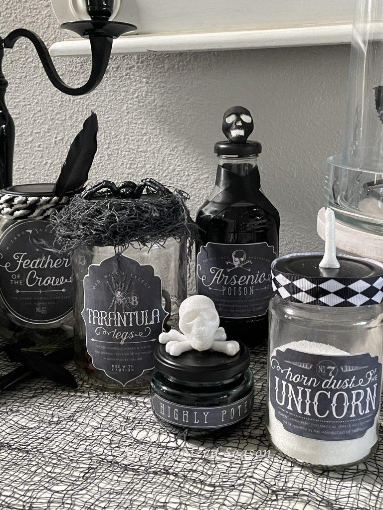 A set of five black and white potion bottles. 