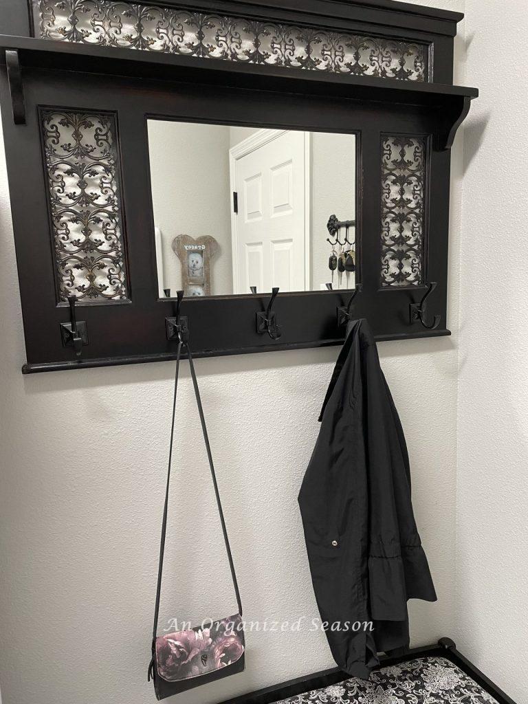 A mirror with hooks to hang a jacket and purse is an idea to create an organized entryway! 