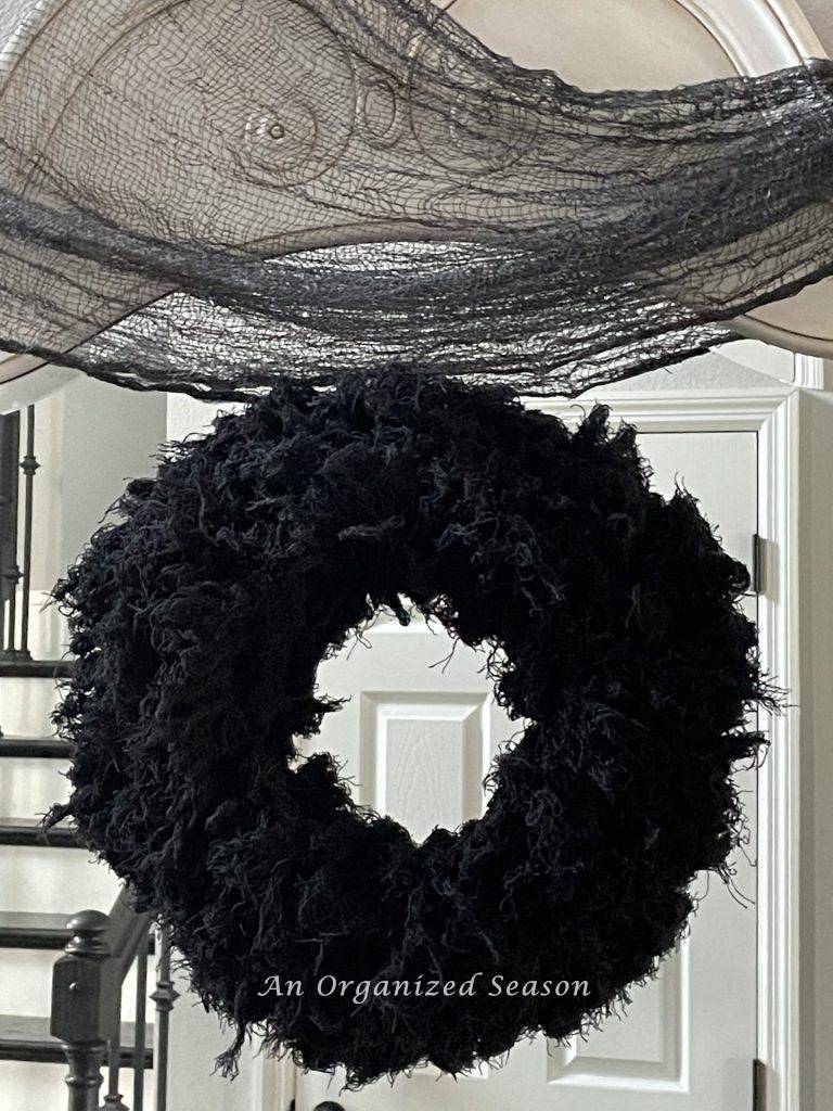 A black wreath made form Dollar Tree creepy cloths. 