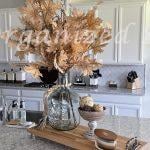 Maple leaves in a glass vase on a kitchen counter