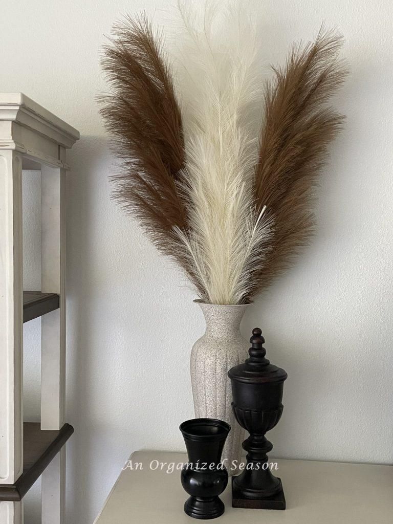 Fall home tour showcasing a stone vase holding pampas grass in front of new paint color on the walls. 