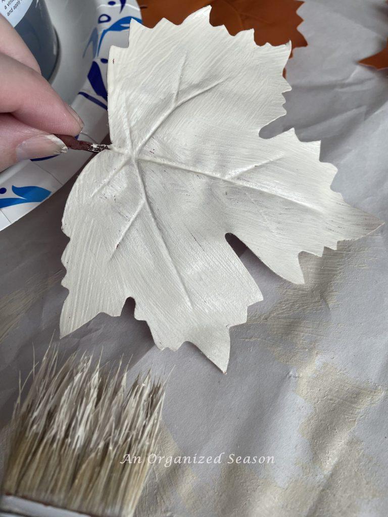 A leather leaf painted white then used to make super easy DIY plate chargers.