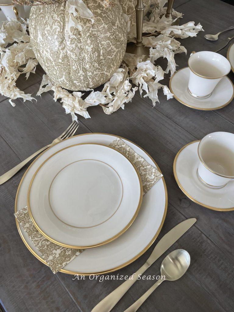 A cream colored set of china on a dining room table. 
