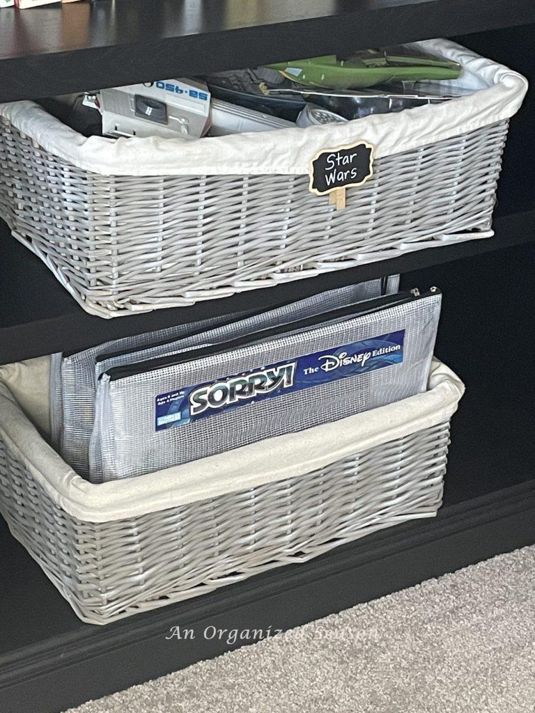 Two baskets with organized toys and board games stored in zipper bags. 