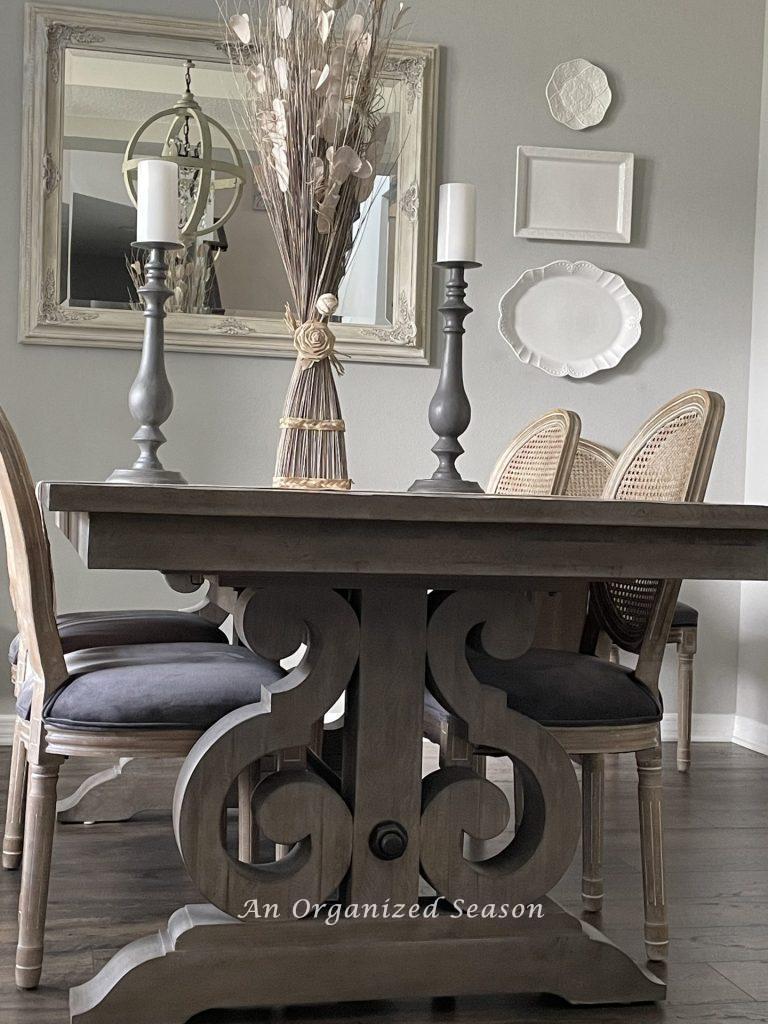 A dining room table with swirled decorative legs. 