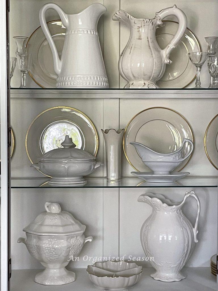 Organize white dishes in a china cabinet! 