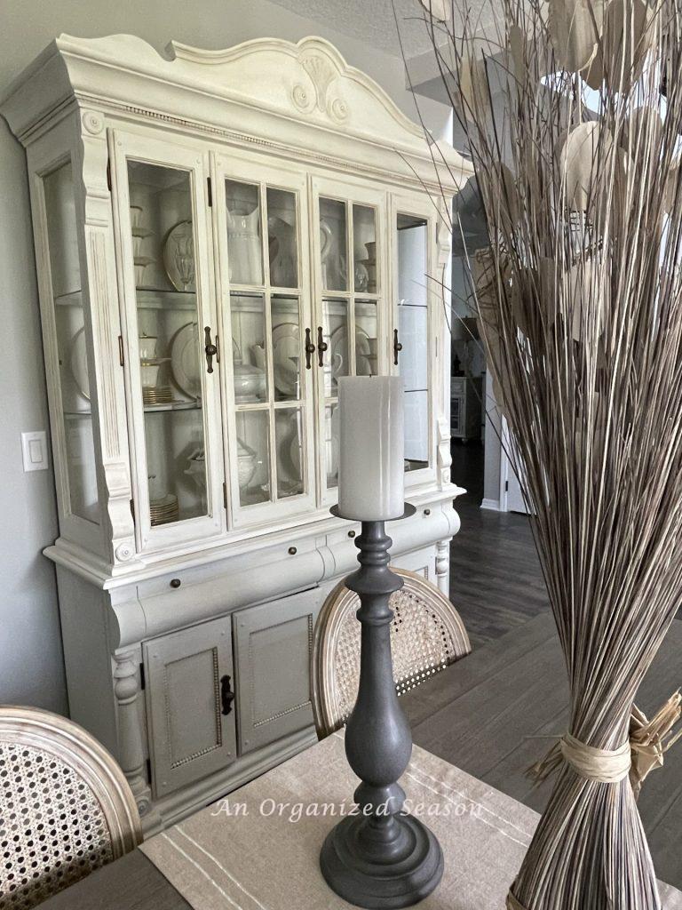 A white china cabinet in a dining room.