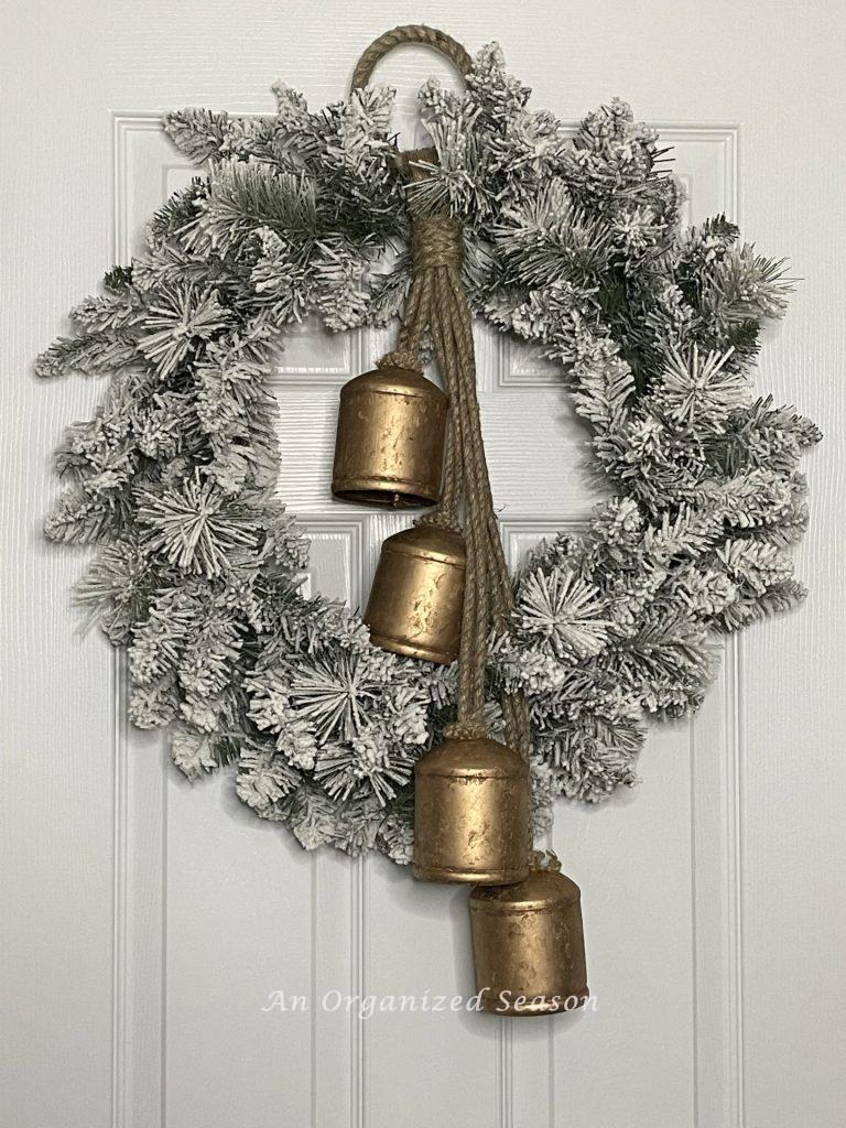 Rustic iron bells hanging from a flocked wreath.