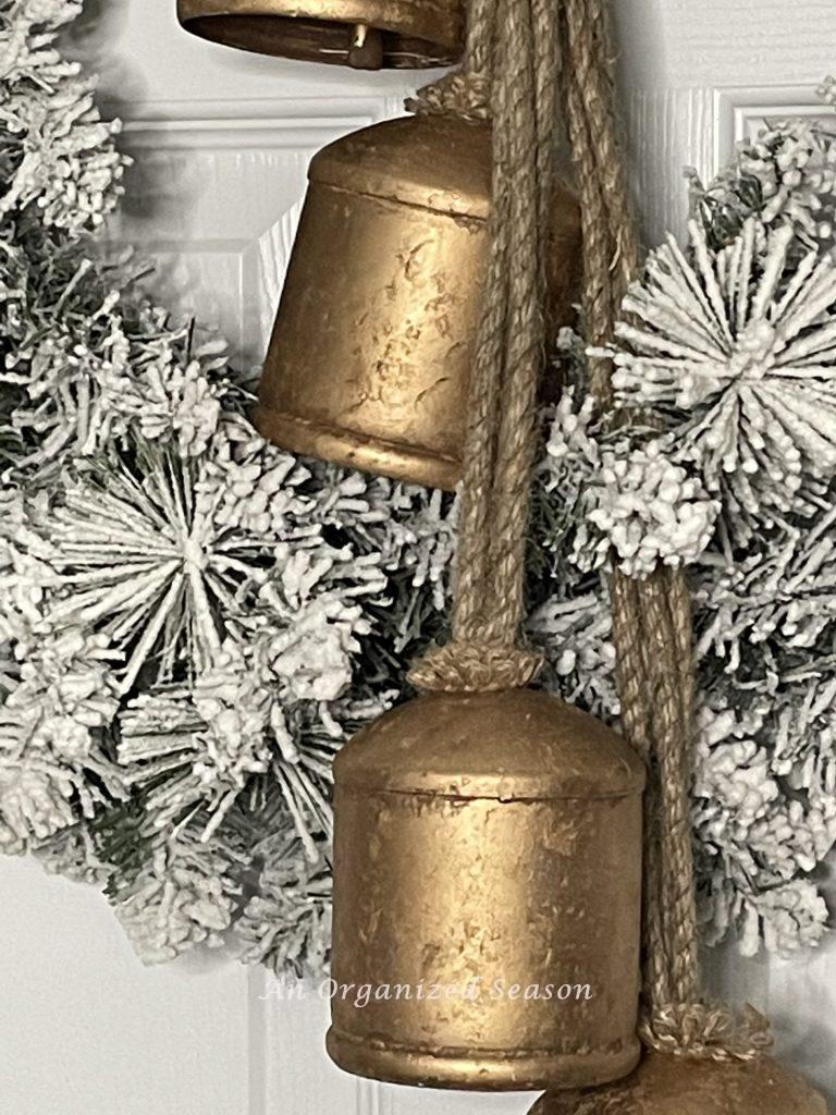 Close-up of rustic bells on a flocked wreath. 