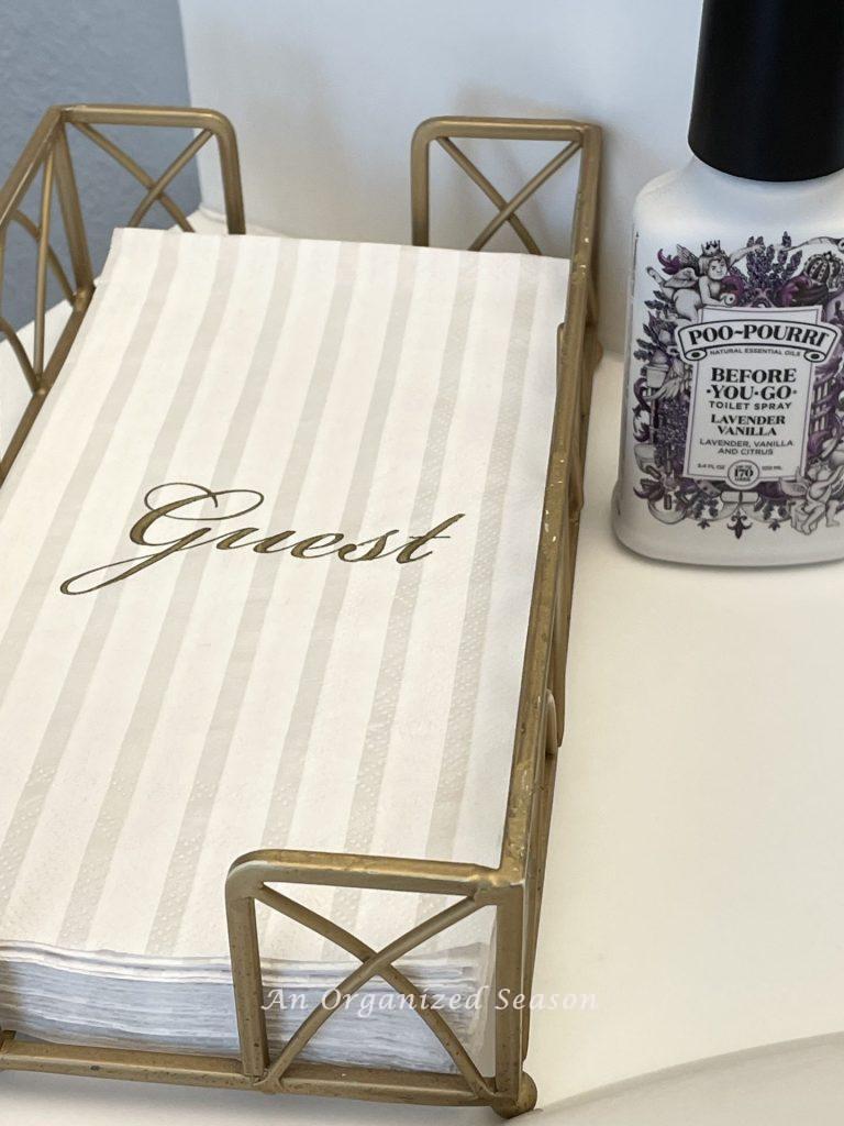 Guest hand towels and Poo-pourri spray on a bathroom counter. 