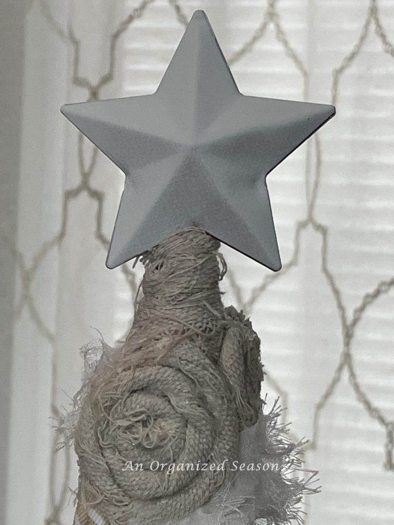 A white star on top of a DIY cone Christmas tree.