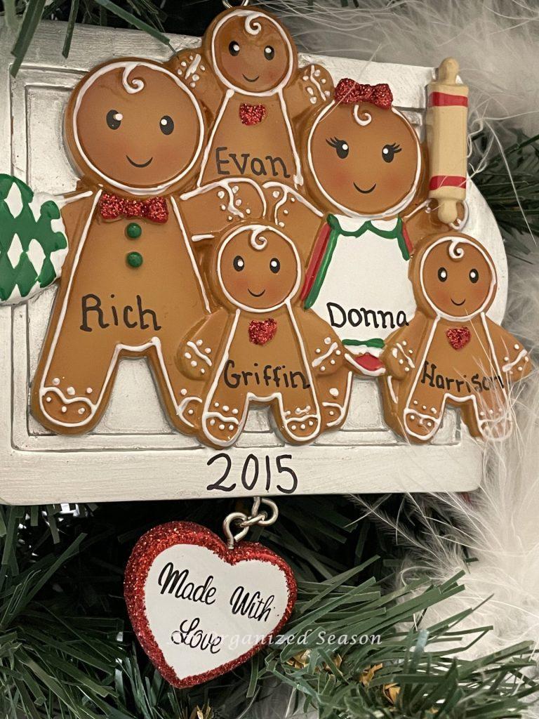 A personalized Christmas ornament showing a family of five gingerbread people on a baking sheet, an example of our family keepsake ornament tradition.