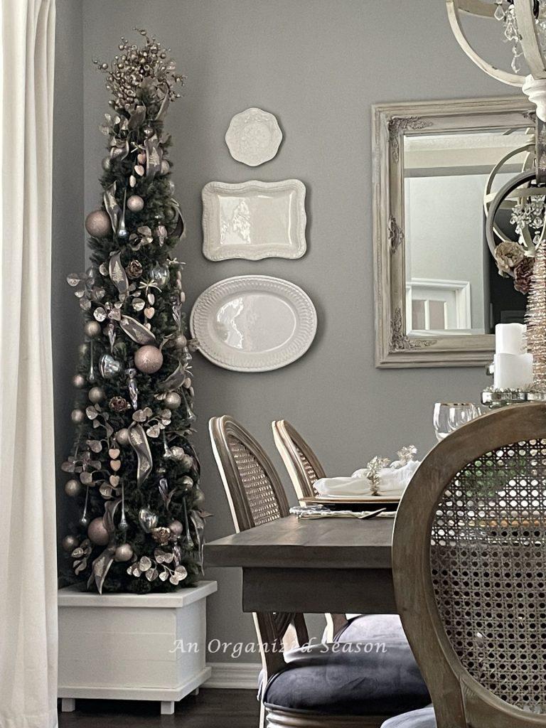 A pink decorated Christmas tree in a dining room. 