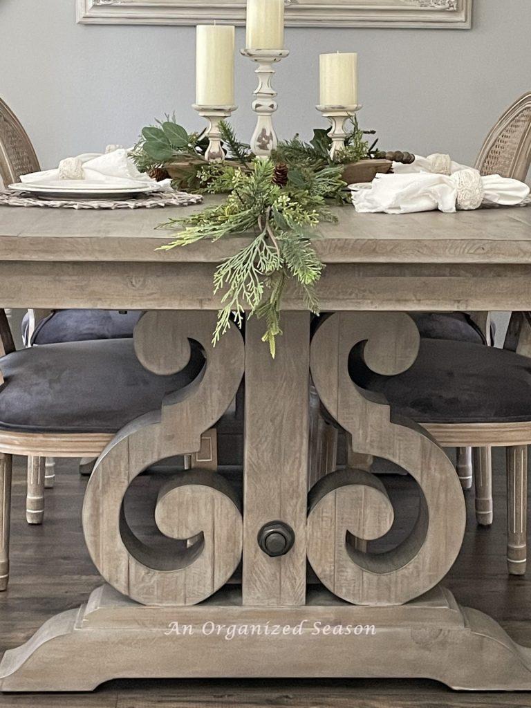 A dining room table decorated with greenery and ready for holiday entertaining.