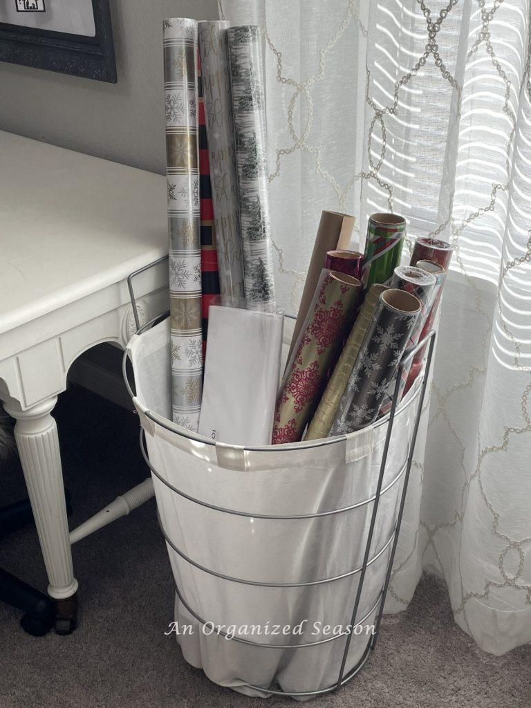 A tall laundry hamper filled with Christmas wrap. Great tips for gift-wrapping.  