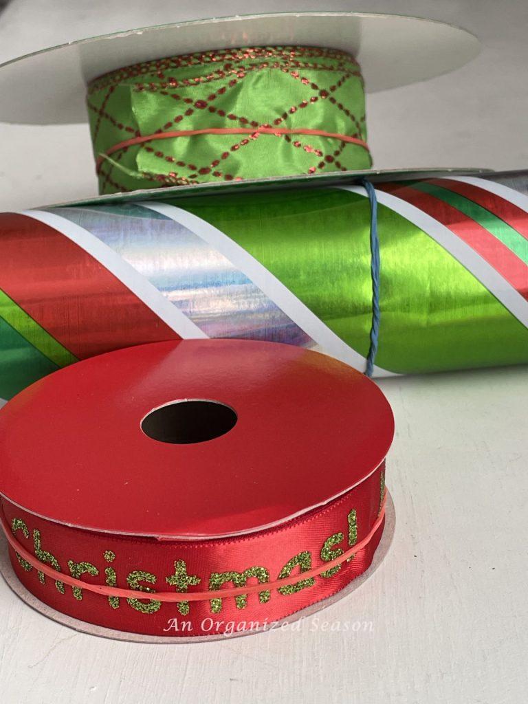 Rubber bands holding gift wrap and ribbon so they can't unroll, great tips for gift wrapping. 