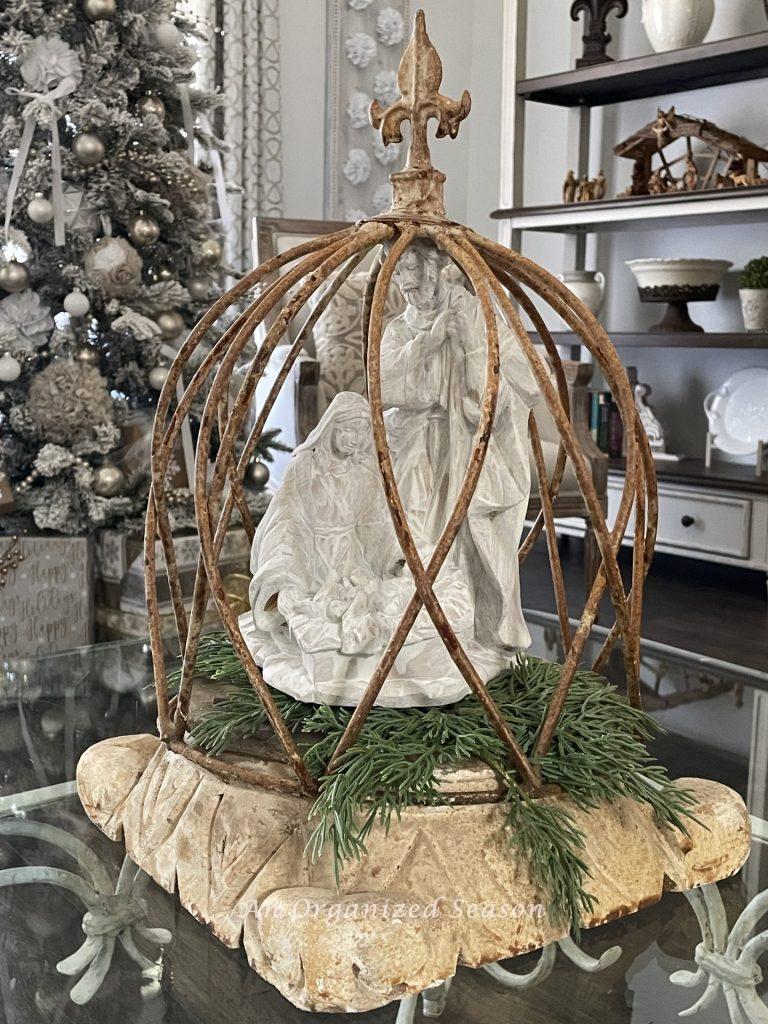 A cloche with a statue of the Holy Family inside. 