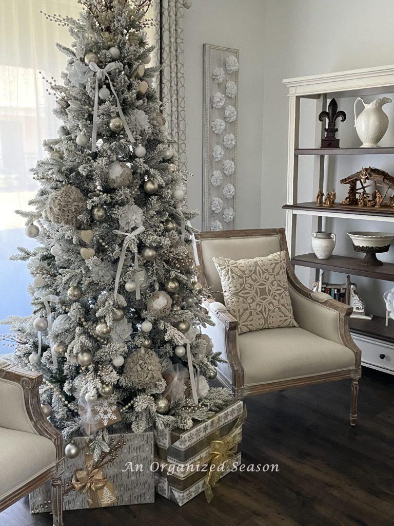 A Christmas tree decorated in neutral colors of white, cream, and champagne. 