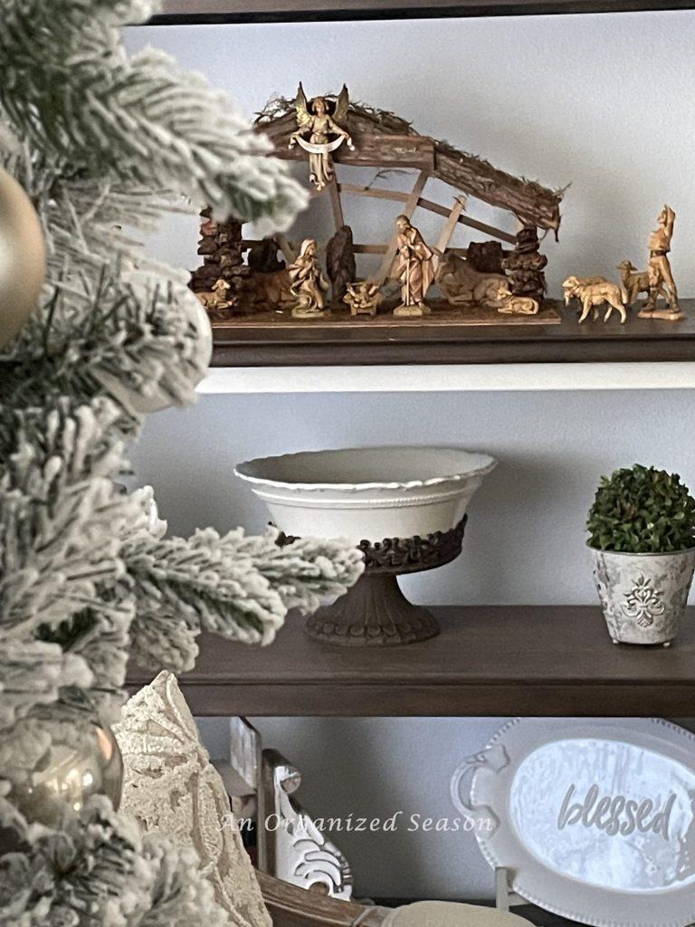 A book shelf with a nativity set displayed on it. 