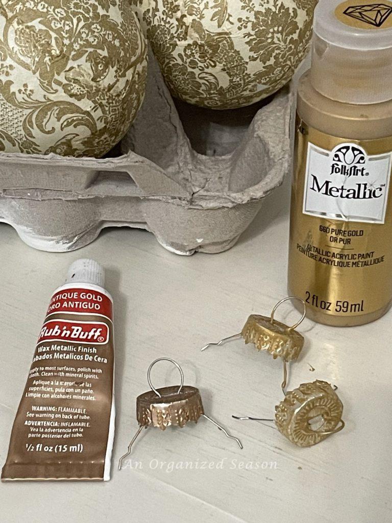 Step seven to make Christmas ornaments with napkins, paint hangers with metallic gold paint.
