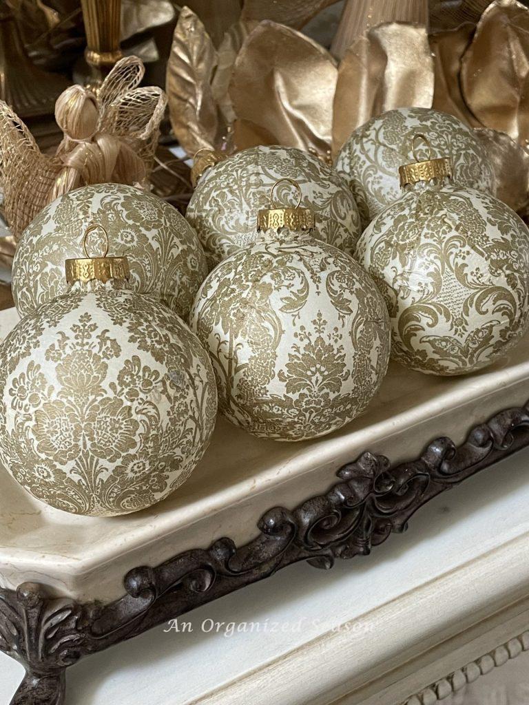 Christmas ornaments decoupaged with gold and cream elegant napkins. 