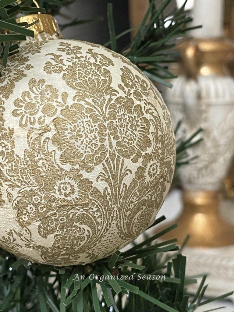 An elegant gold and cream decoupaged Christmas ornament. 