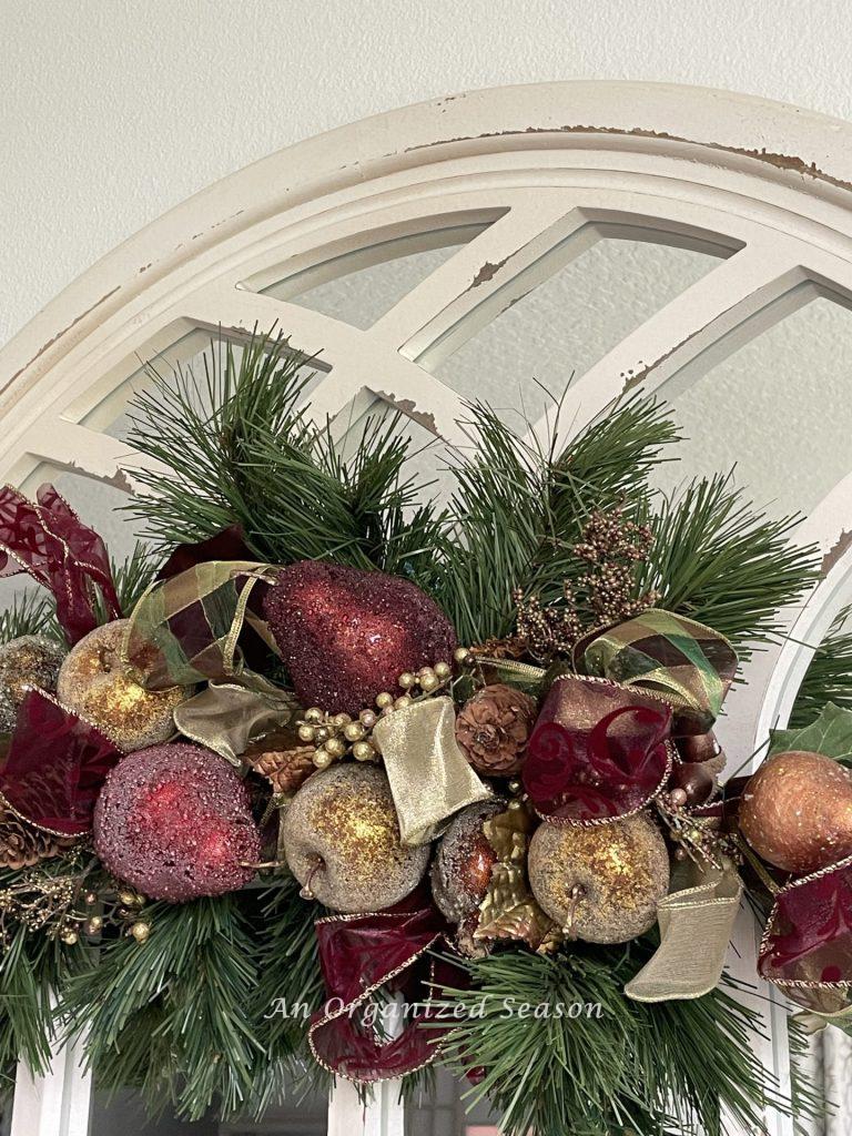 A fruit swag hangs on a mirror decorating for Christmas in a kitchen.  