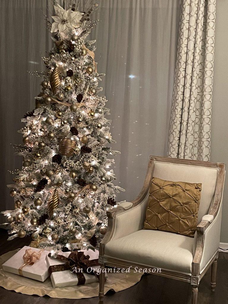 A Christmas tree in a living room with white wrapped gifts underneath. 