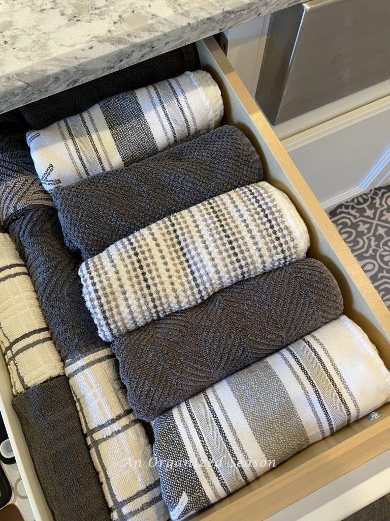 Kitchen towels and dish clothes rolled and placed in a drawer during the Winter Home Organization Challenge.