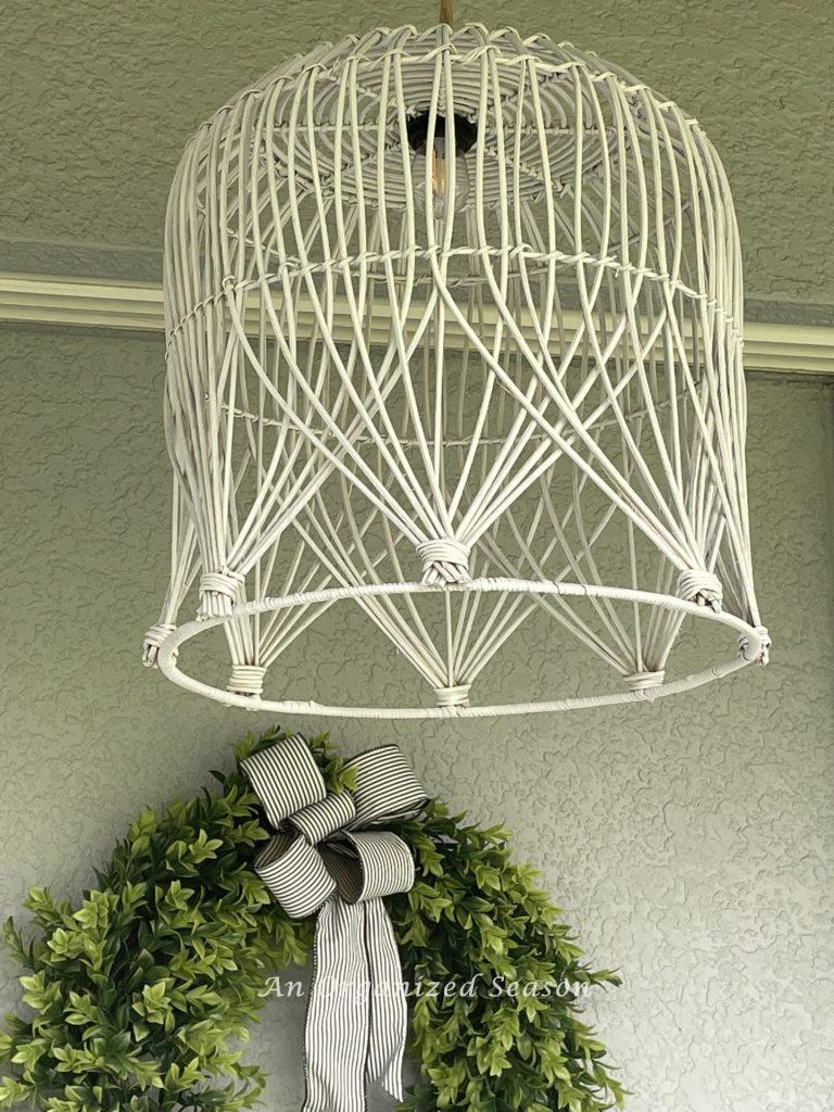 A pendant light fixture made out of a white basket. 