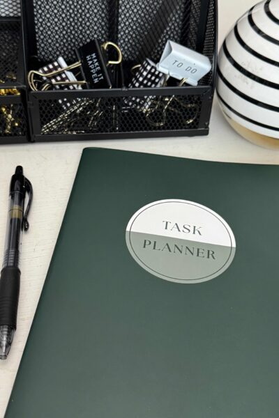 A task planner and ink pen laying on a desk.