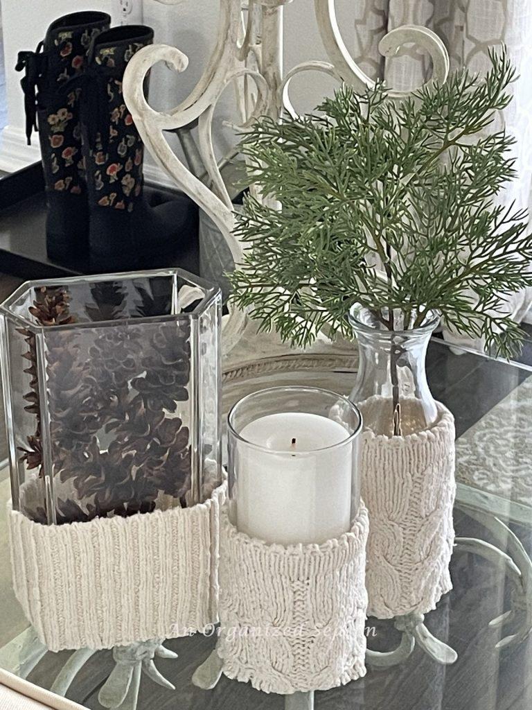 Three glass vases covered in cozies made from an old sweater.