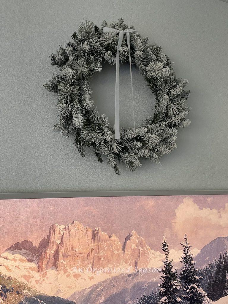 A flocked evergreen wreath with a white velvet bow on top is a great example of Winter decor ideas that don't look like Christmas! 