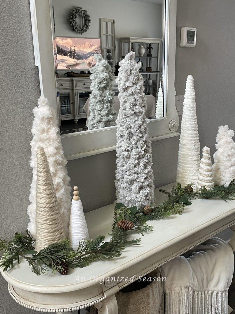 Seven cone shaped trees covered in chunky yarn.