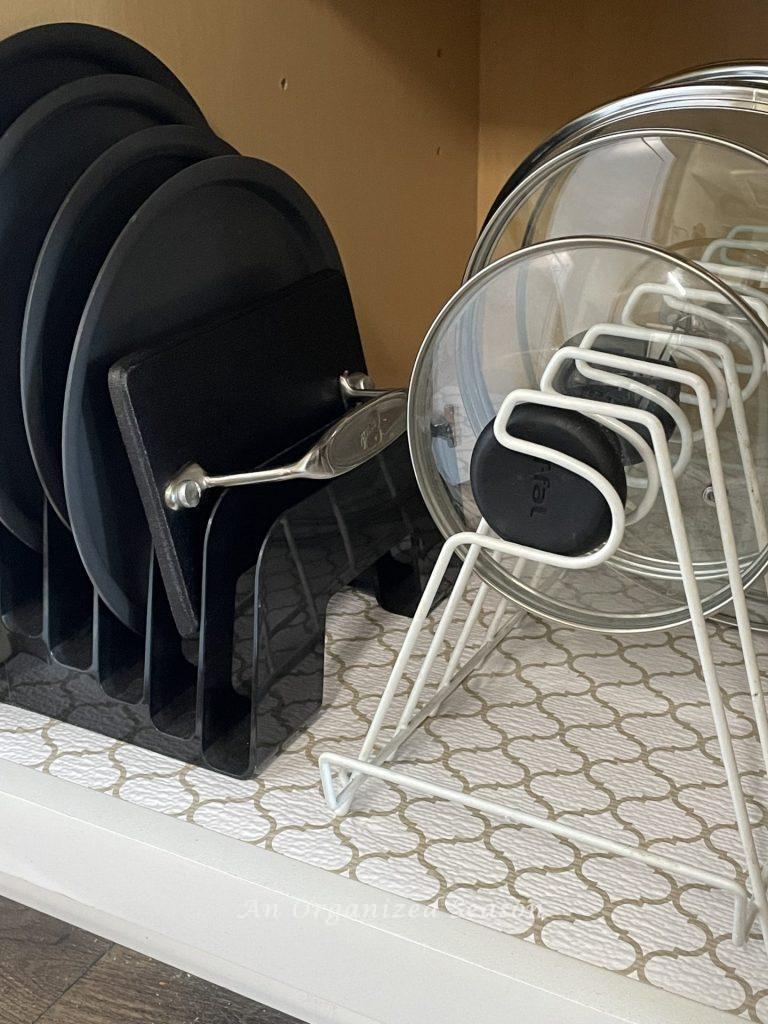 Kitchen storage solution number eight is to use a pot lid organizer for glass lids in a kitchen cabinet. 