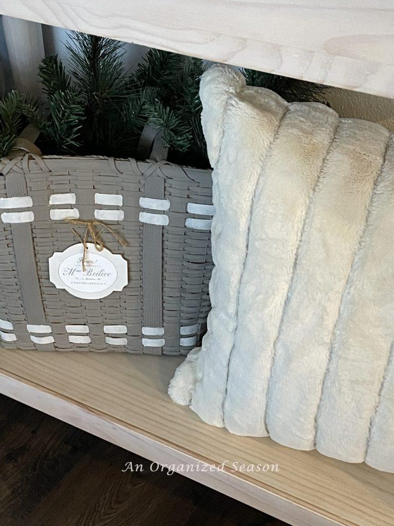 A faux fur pillow next to a basket is a good example of  Winter decor ideas that don't look like Christmas!