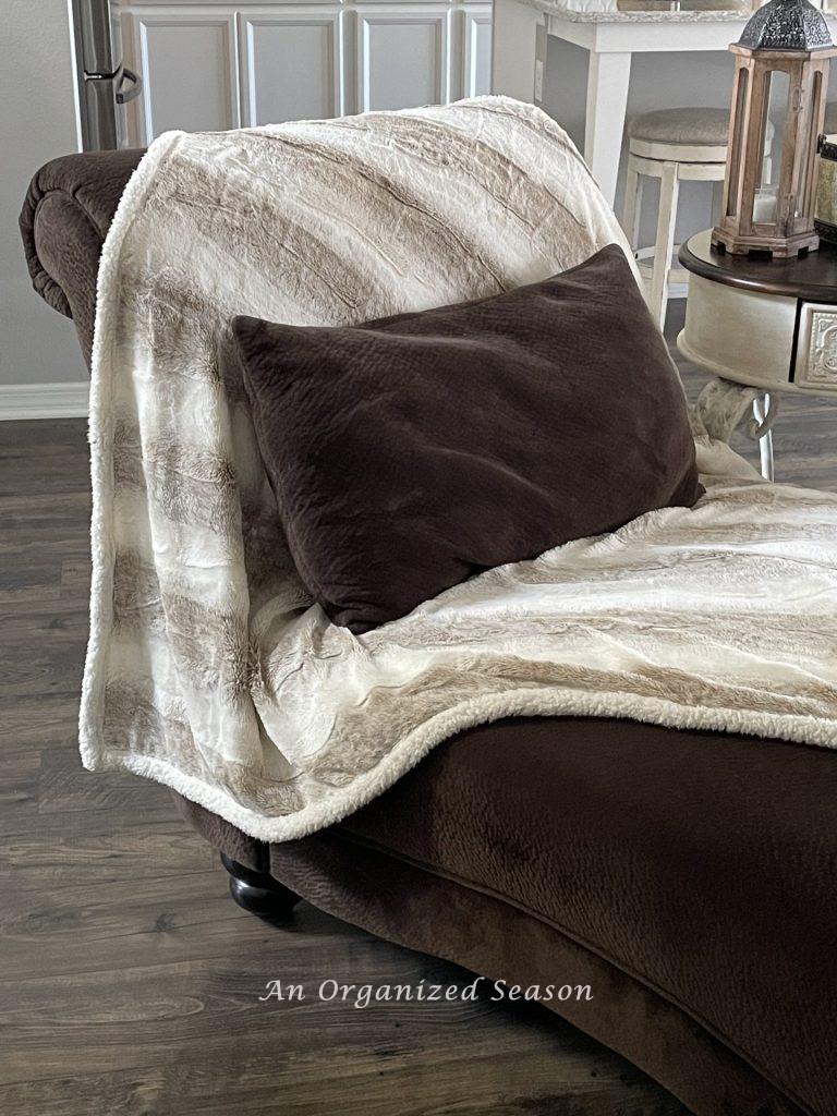 A faux fur throw blanket draped over a chaise lounge is a great example of  Winter decor ideas that don't look like Christmas!