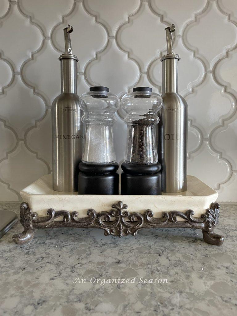 Put your oil and vinegar, salt, and pepper in pretty containers and display them on a tray to declutter and decorate your kitchen counter. 