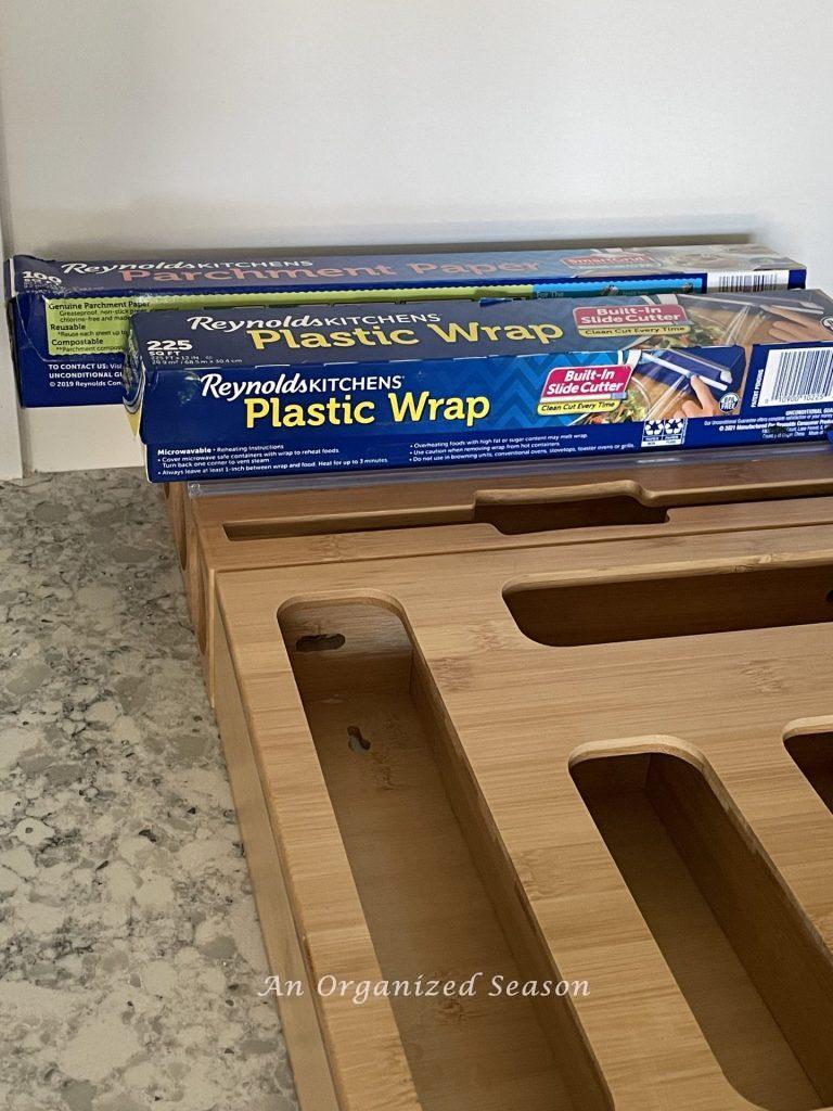 Plastic wrap and parchment paper that are too long for a bamboo kitchen wrap organizer. 