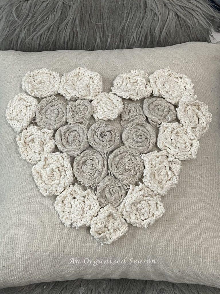 Rosettes made from sweater scraps and drop cloth pieces on a Valentine's pillow. 