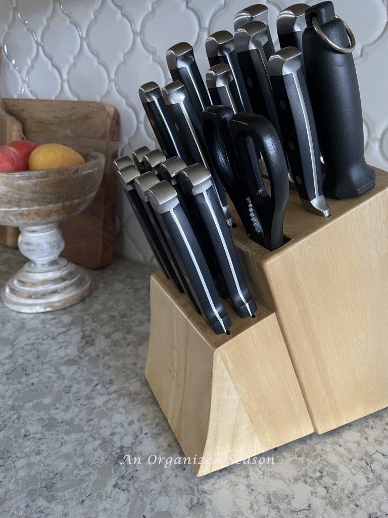 A wooden knife block holding knives, a sharpener, and scissors is a great way to declutter and decorate your kitchen counter at the same time. 