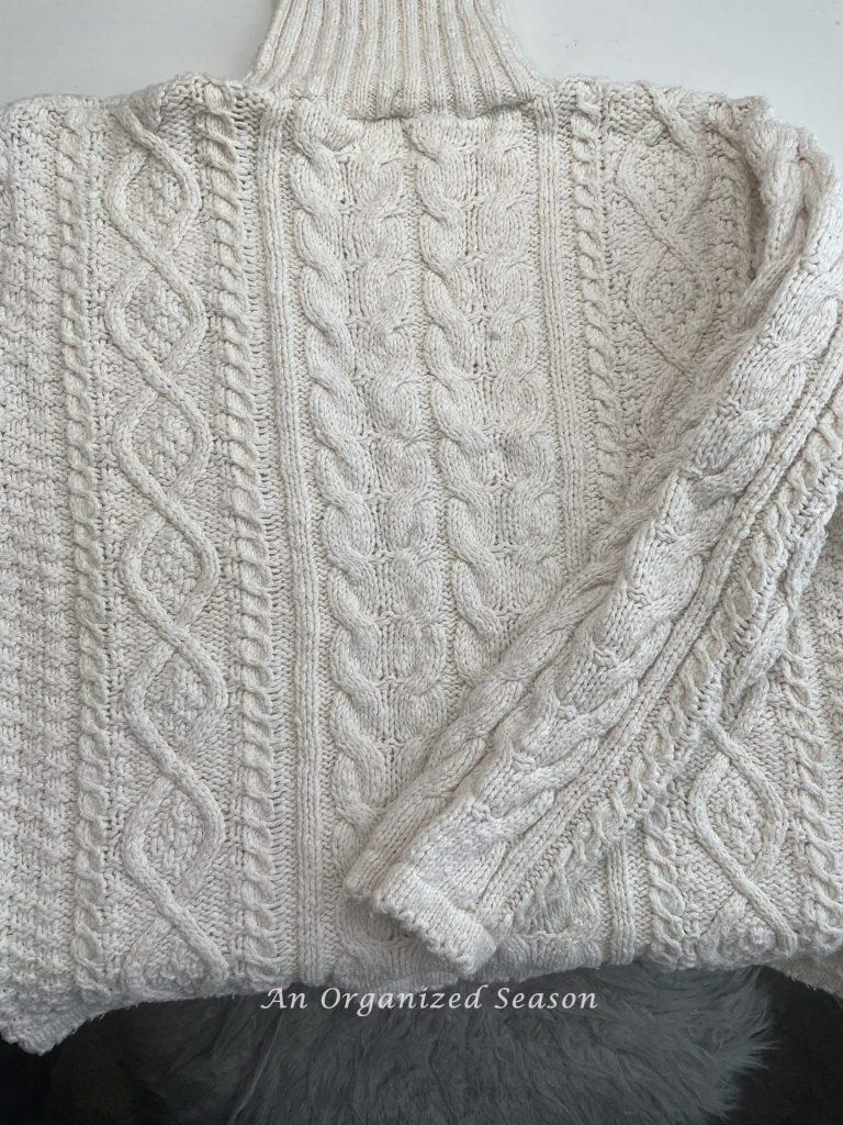 A cream cable knit sweater that will be used to make cozy home decor! 