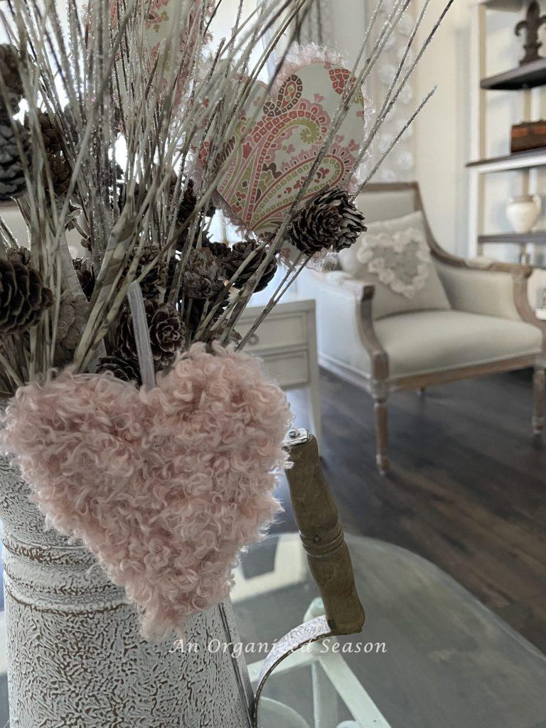 A yarn heart hanging from branches.