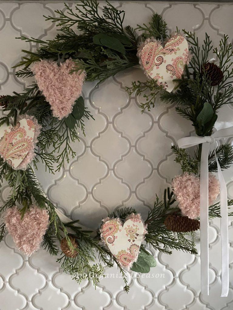 A wreath covered with paper and yarn Valentine's hearts. 