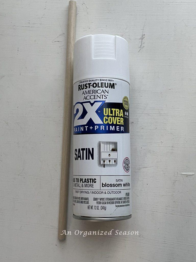 A dowel rod and can of white spray paint. 