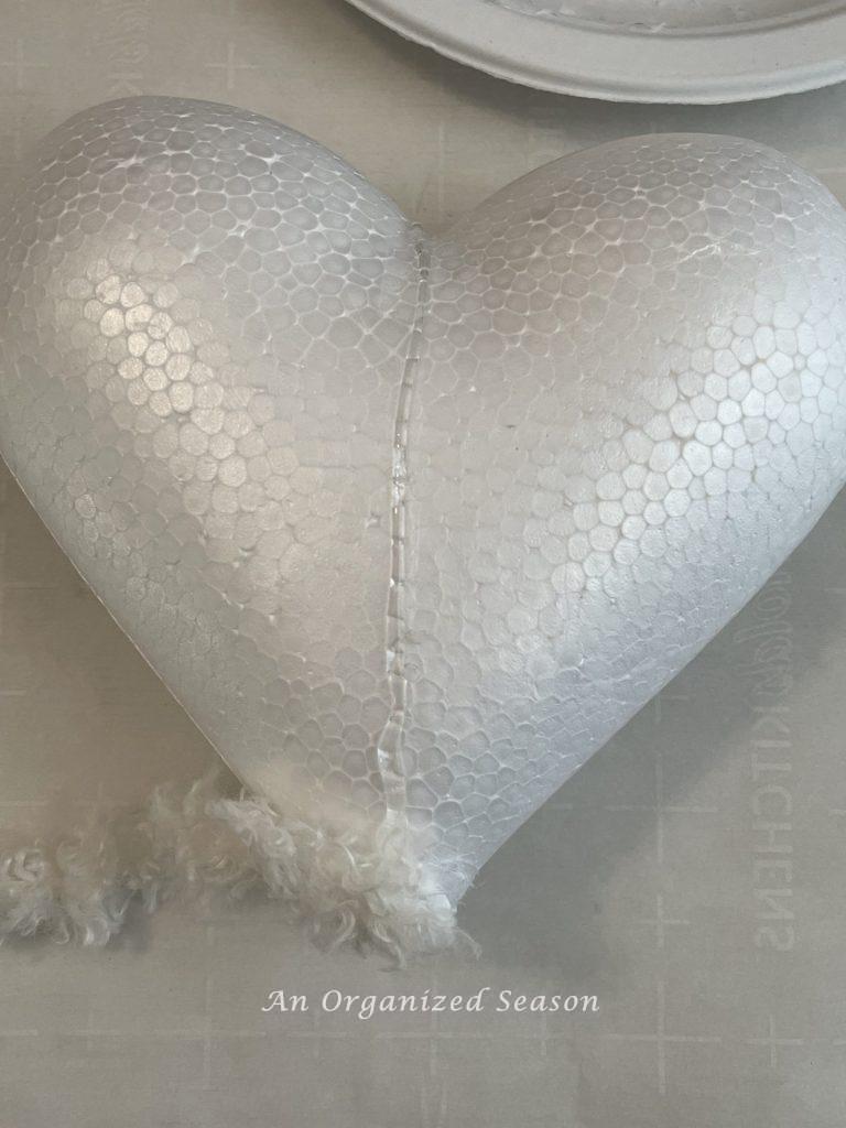 Hot glue strip on a Dollar Tree heart ready to make a DIY topiary.